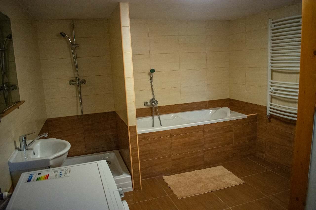 Koupelna s vanou, sprchovým koutem, toaletou a pračkou