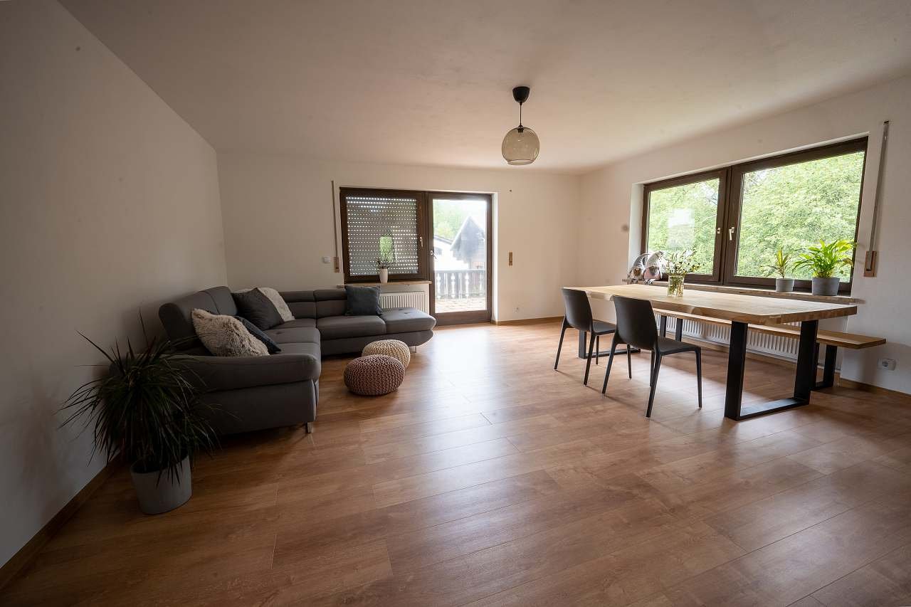 Obývací pokoj s dřevěným nábytkem a rozkládací sedací soupravou