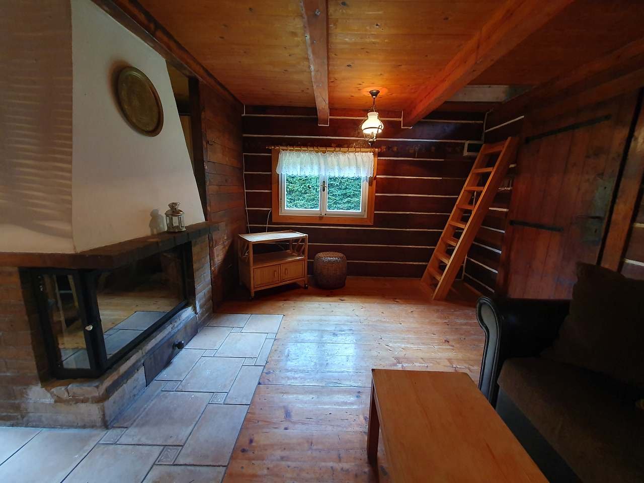 Obývací pokoj s krbem a přístupem do ložnice v podkroví