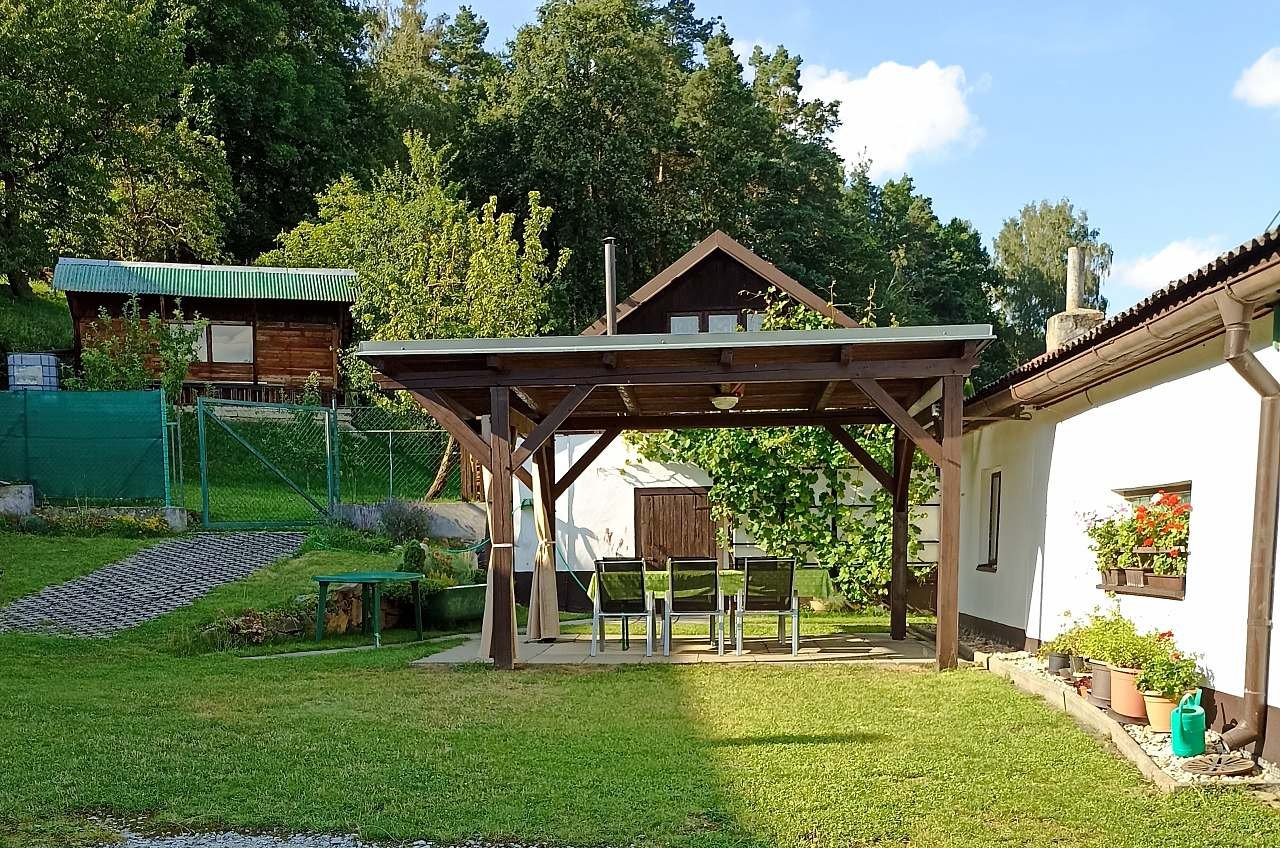 Pergola v oploceném dvorku se střechou proti dešti