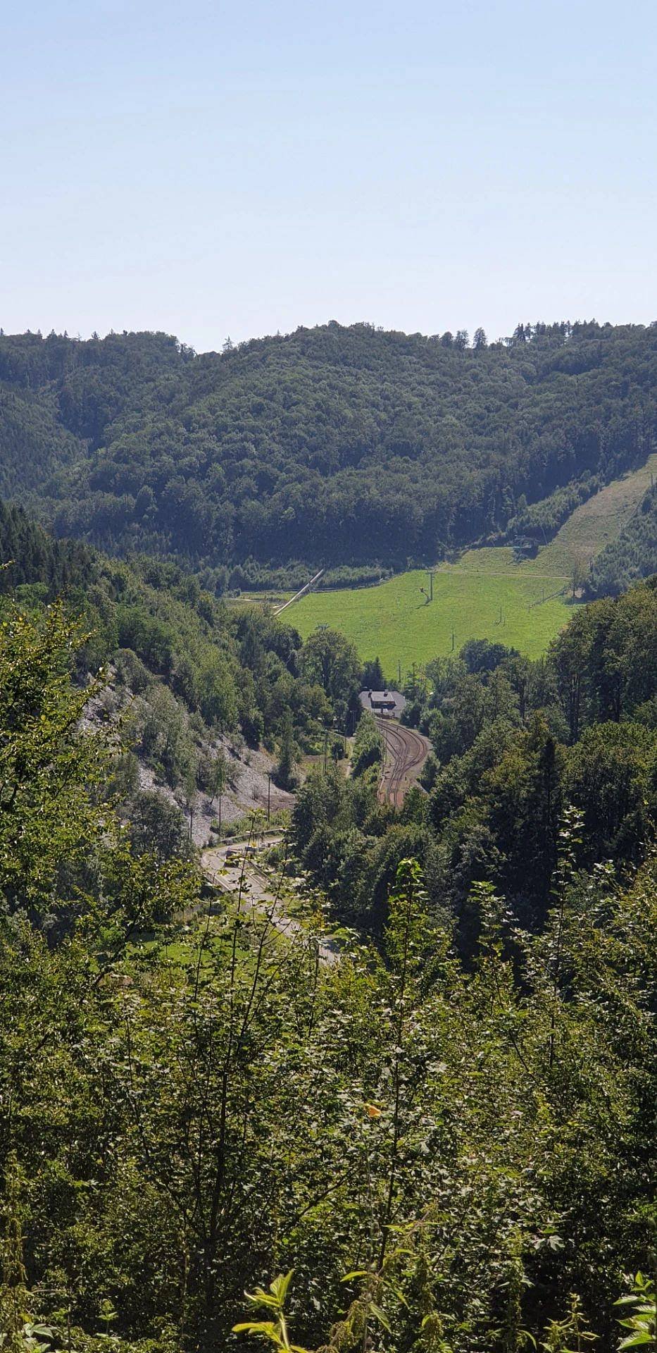 Pohled z okolní turistické trasy, střecha chalupy je vidět dole.