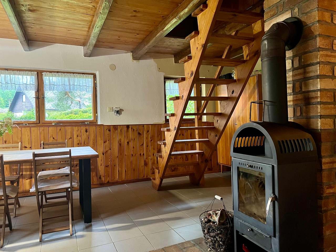 Společenská místnost, krb a schody do podkroví